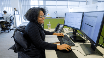 CoStar office employee works at computer desk